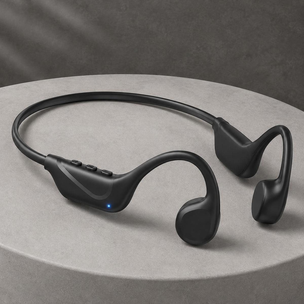 Windryft Aero open-ear bone conduction headphones in black, resting on a stone pedestal, showing the flexible titanium neckband and the two driver pads